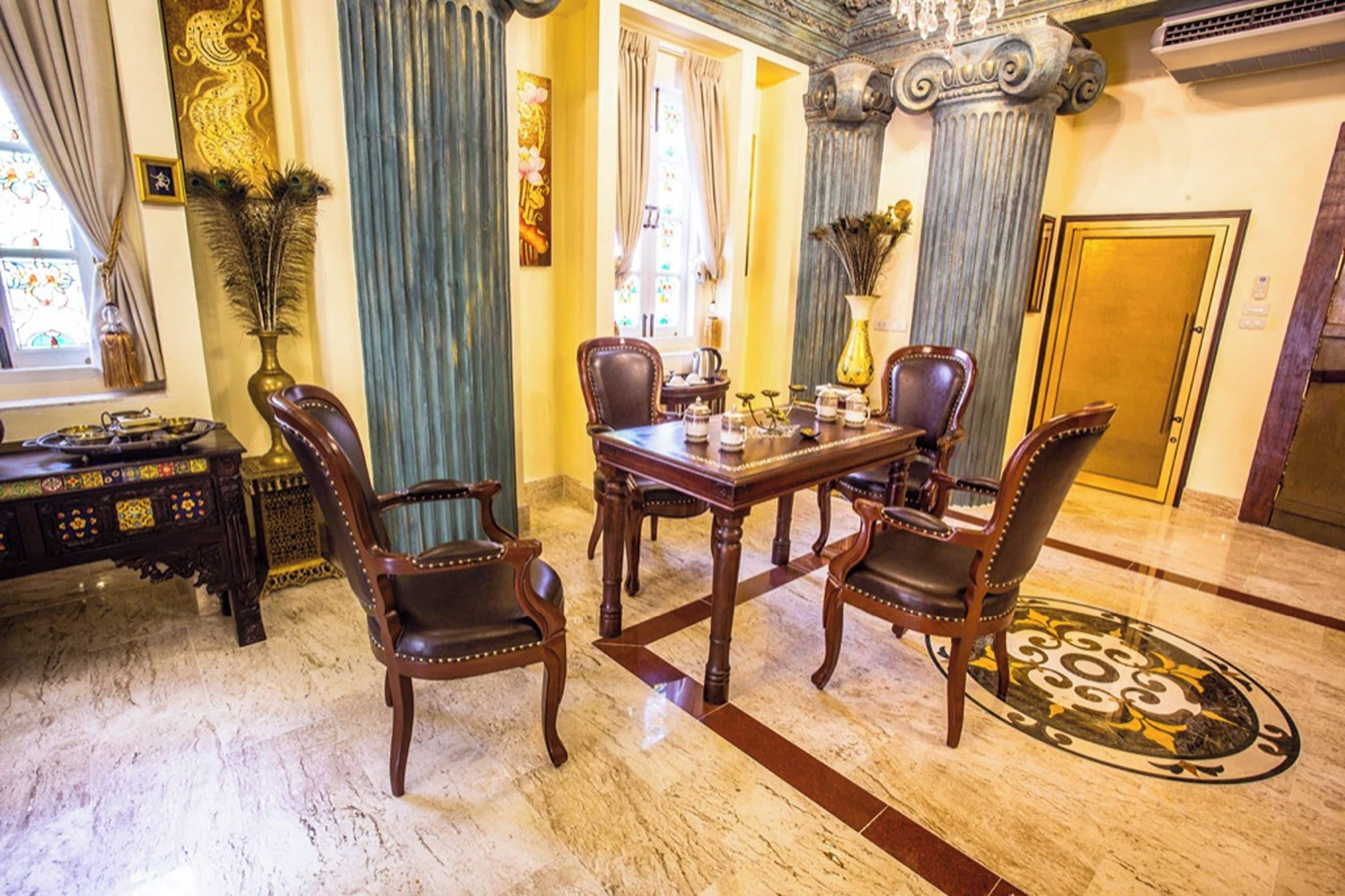 A formal dining room with a marble floor, a wooden table, and four upholstered chairs.