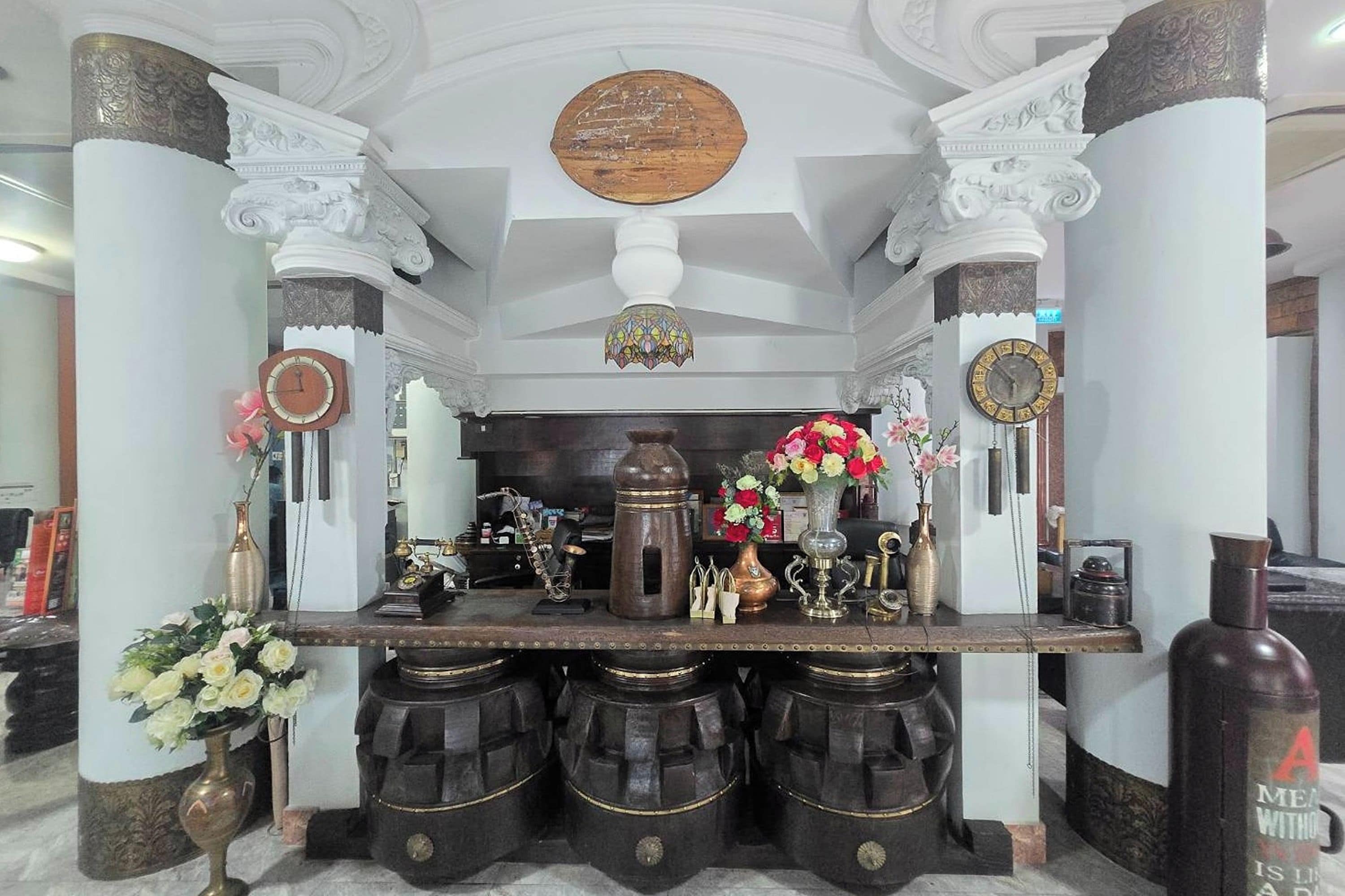 Une pièce dotée d’une table centrale, de colonnes et d’un plafond décoratif.