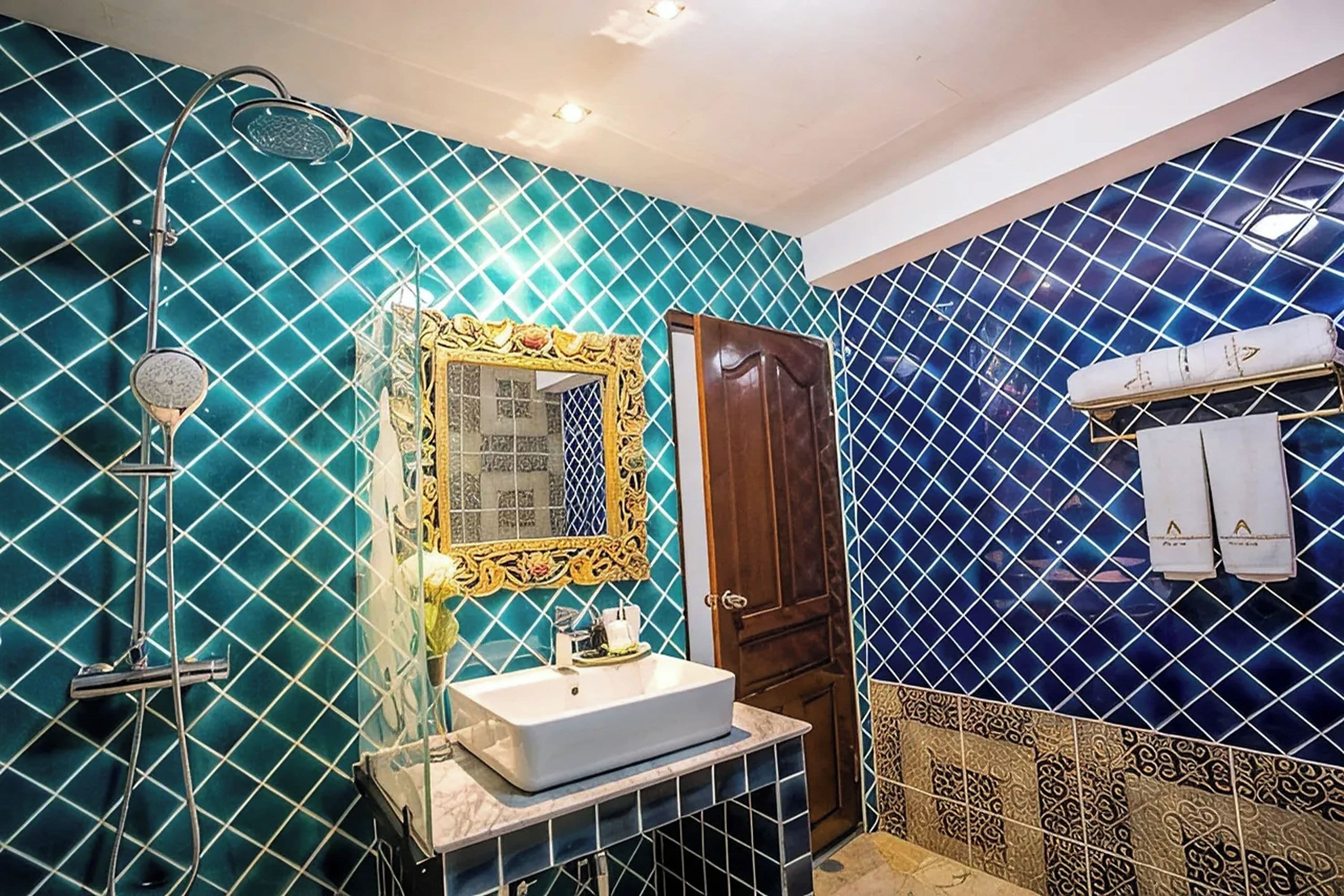 A bathroom with a sink, mirror, shower, and towel rack.