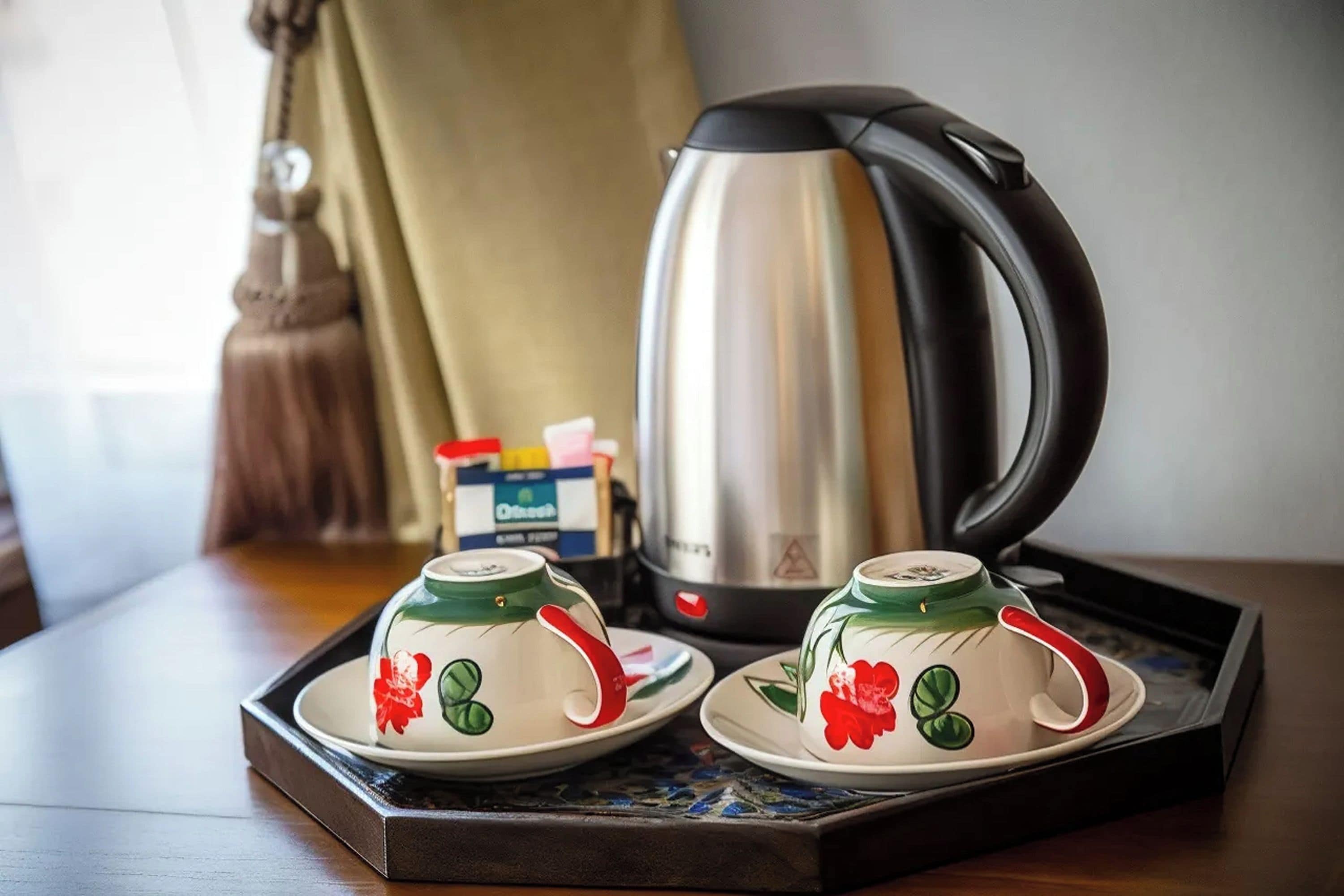 Un plateau avec deux tasses à thé et une théière, posé sur une table.