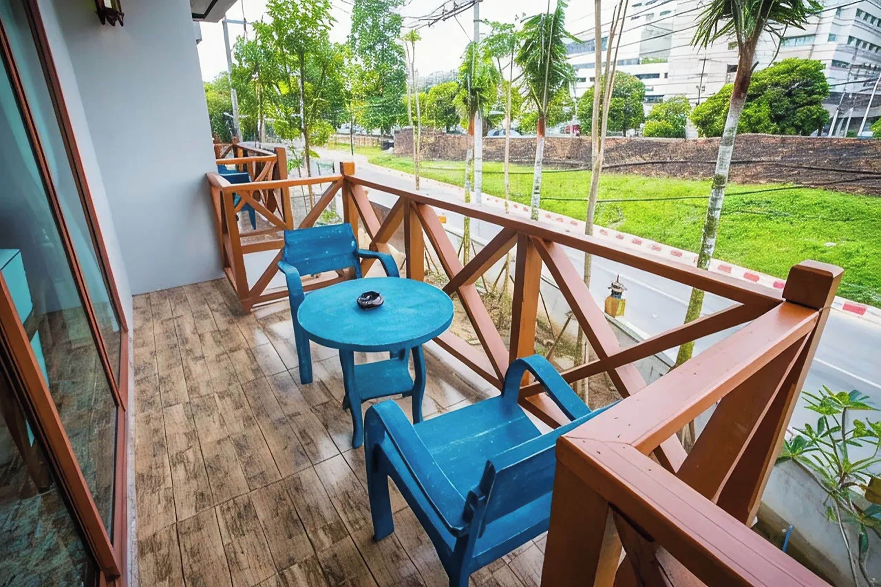 A balcony with wooden railings, a blue table, and matching chairs.