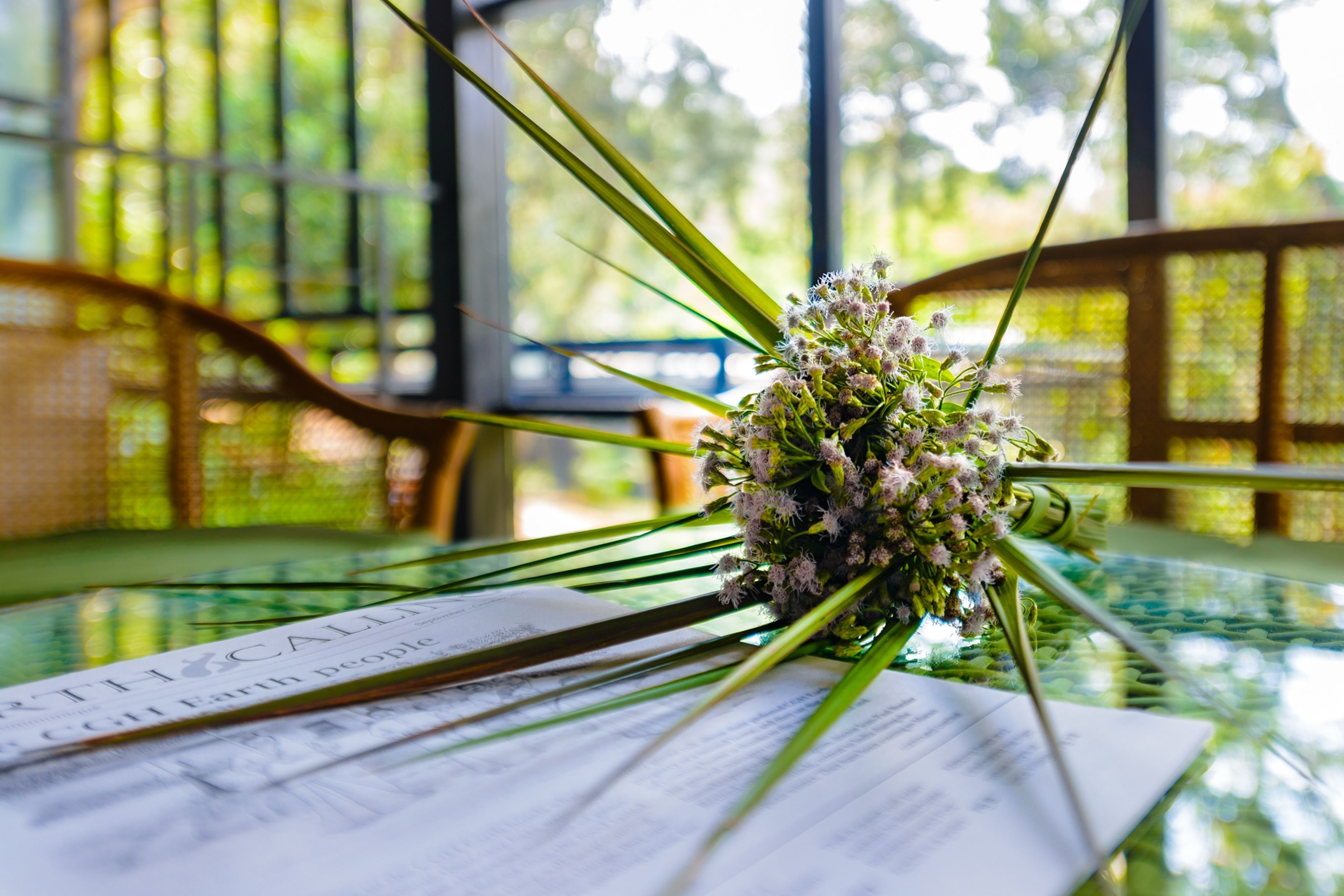 A glass table with a bouquet of flowers and a menu.