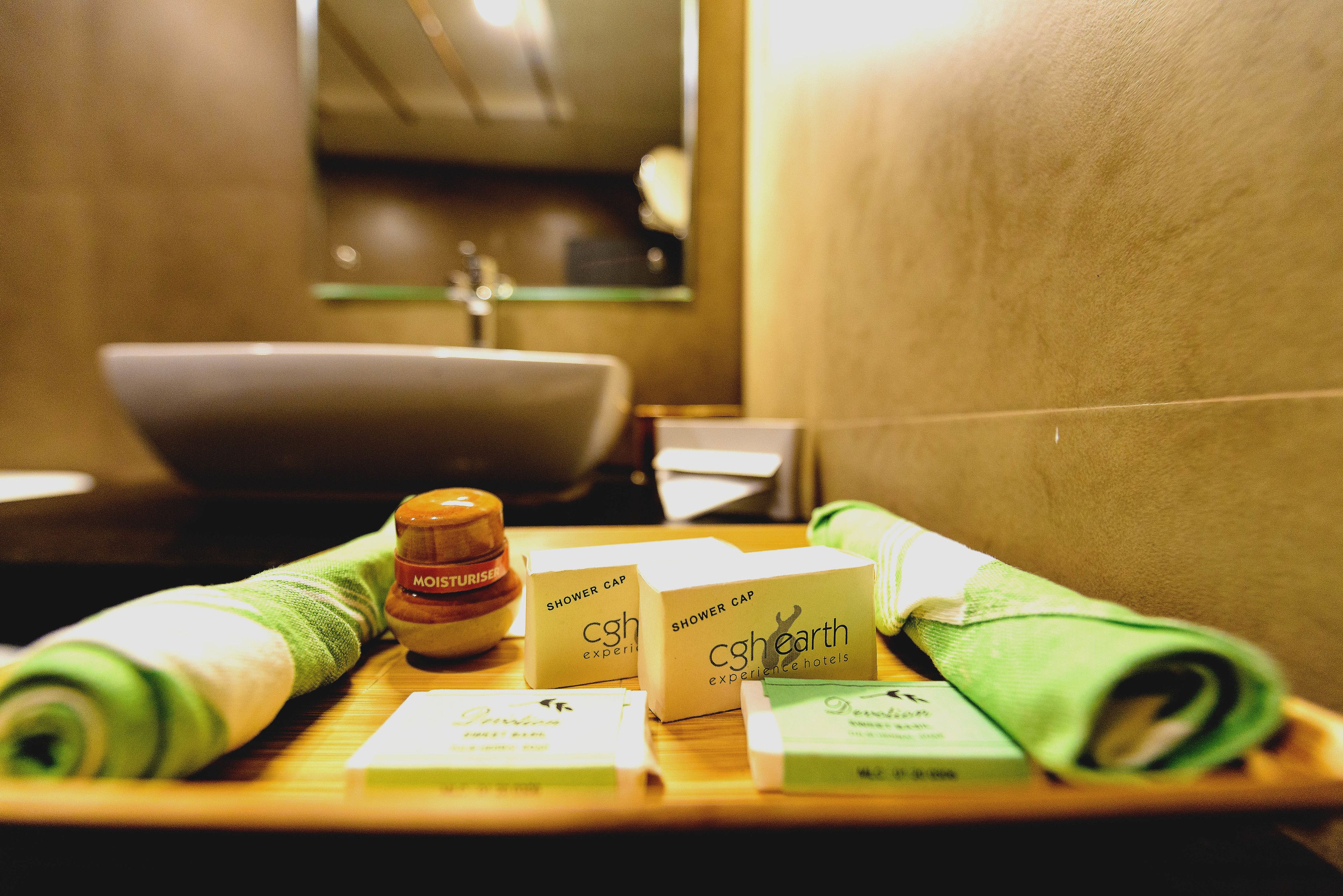 A bathroom with a sink, a mirror, and toiletries on a tray.