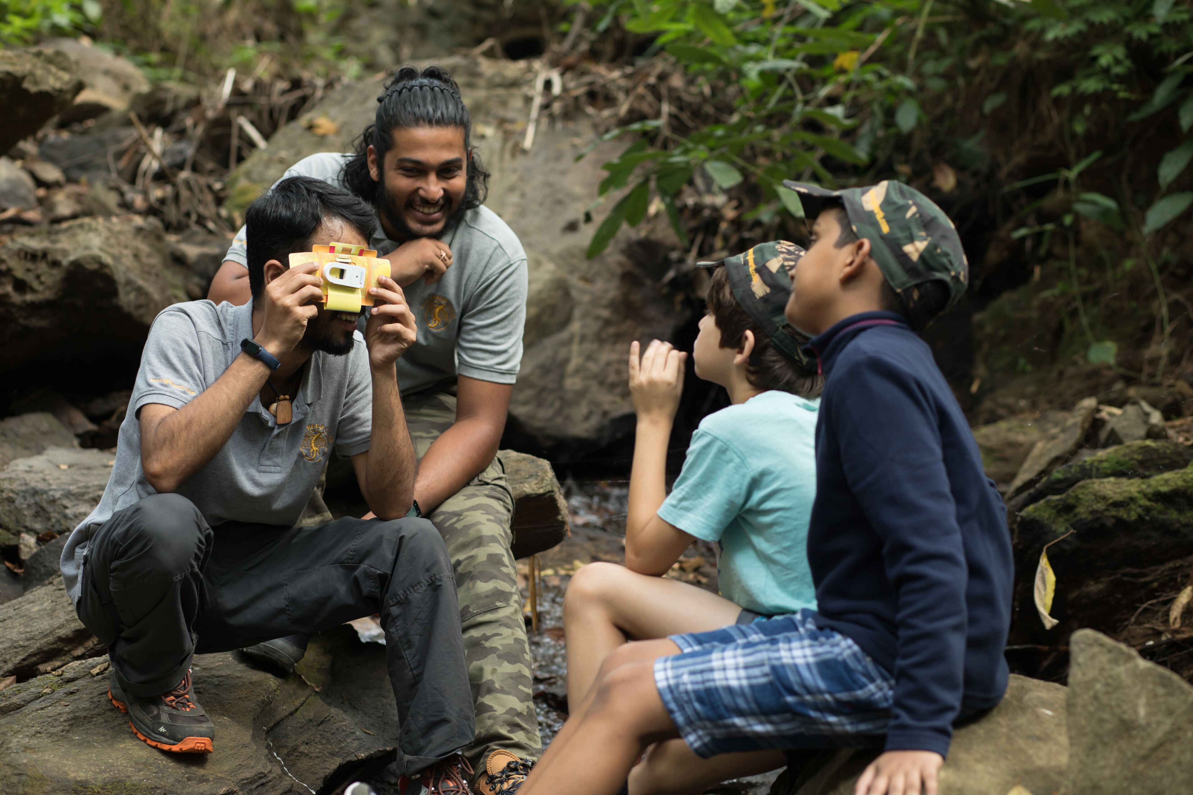 A group of people sitting on rocks outdoors.