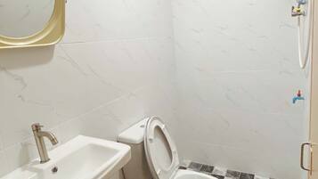 Un baño con inodoro, lavamanos y espejo.