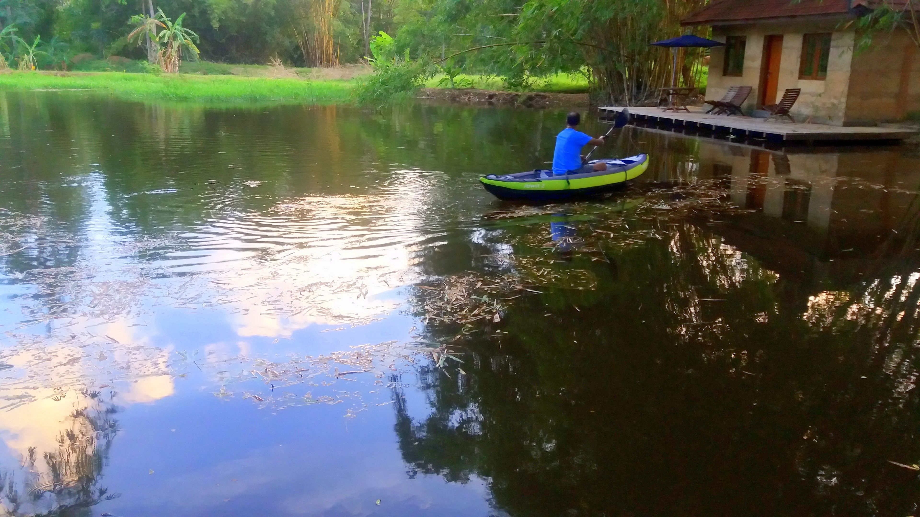 A man paddling a kayak on a calm river.