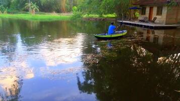 A man paddling a kayak on a calm river.