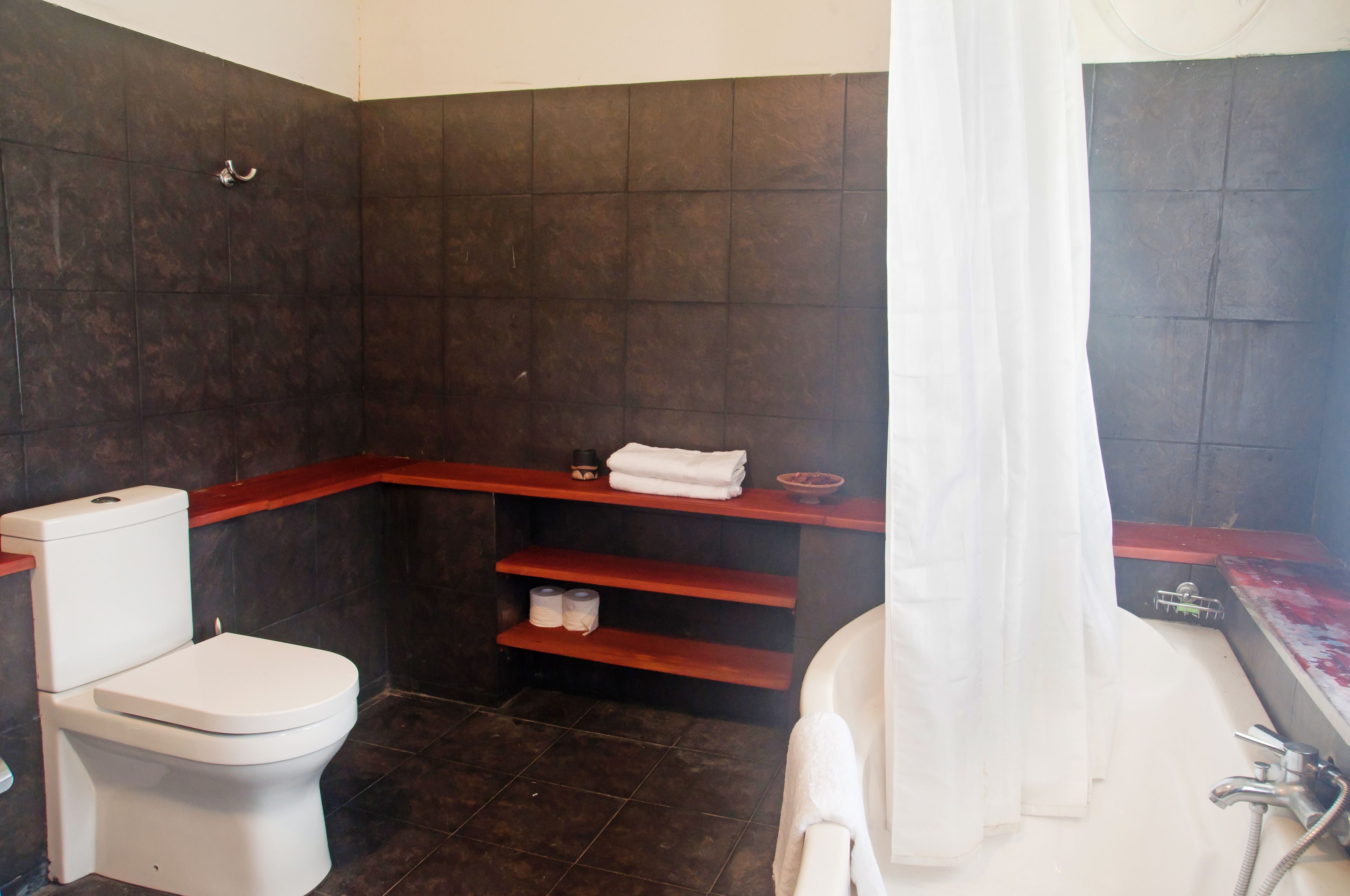 A bathroom with a toilet, a sink, a bathtub, and a shower curtain.