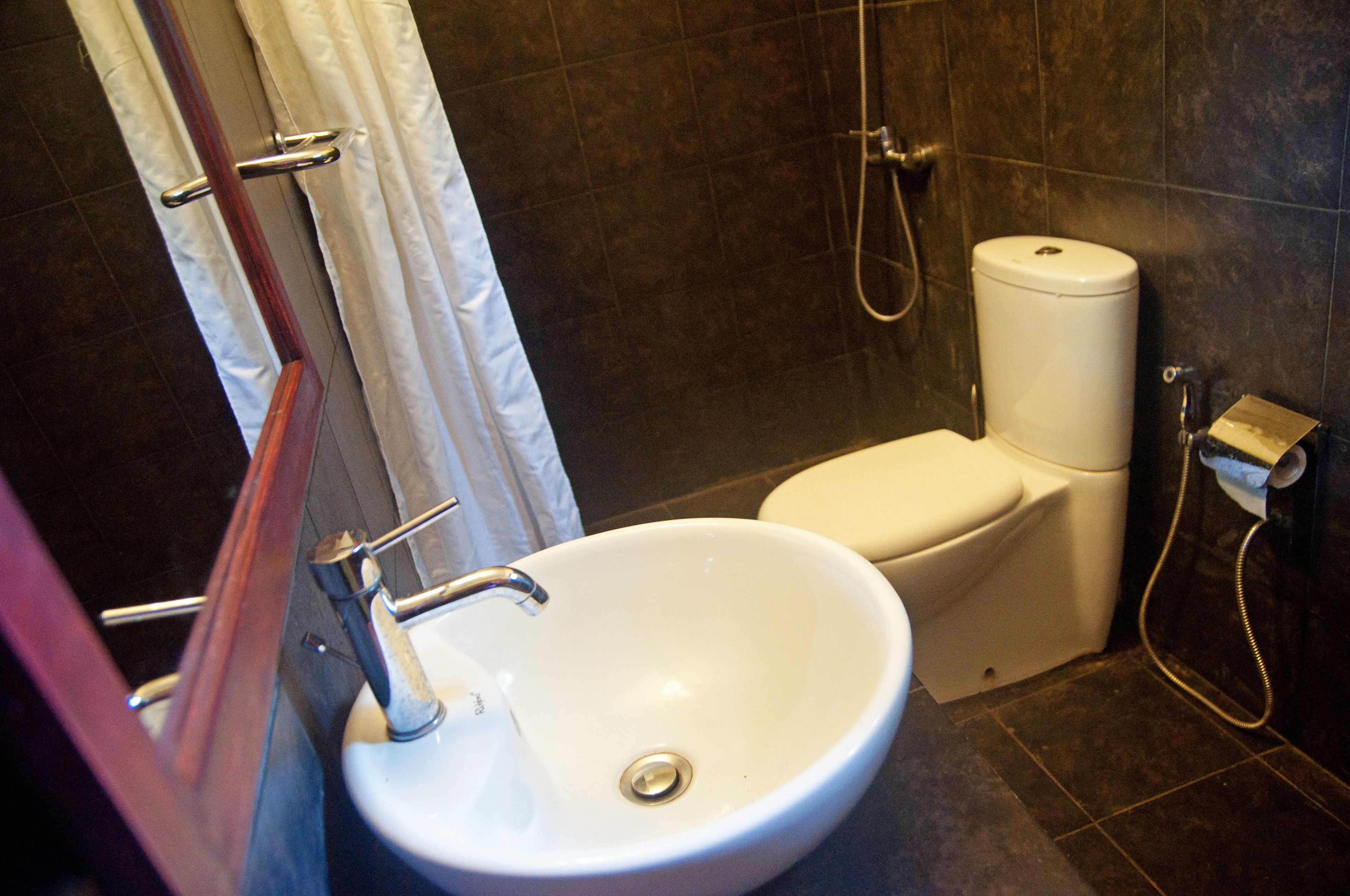 A bathroom with a white sink, toilet, and shower.