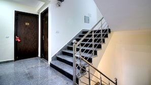 Una escalera con barandilla de metal y una puerta de madera oscura con la etiqueta '104'.