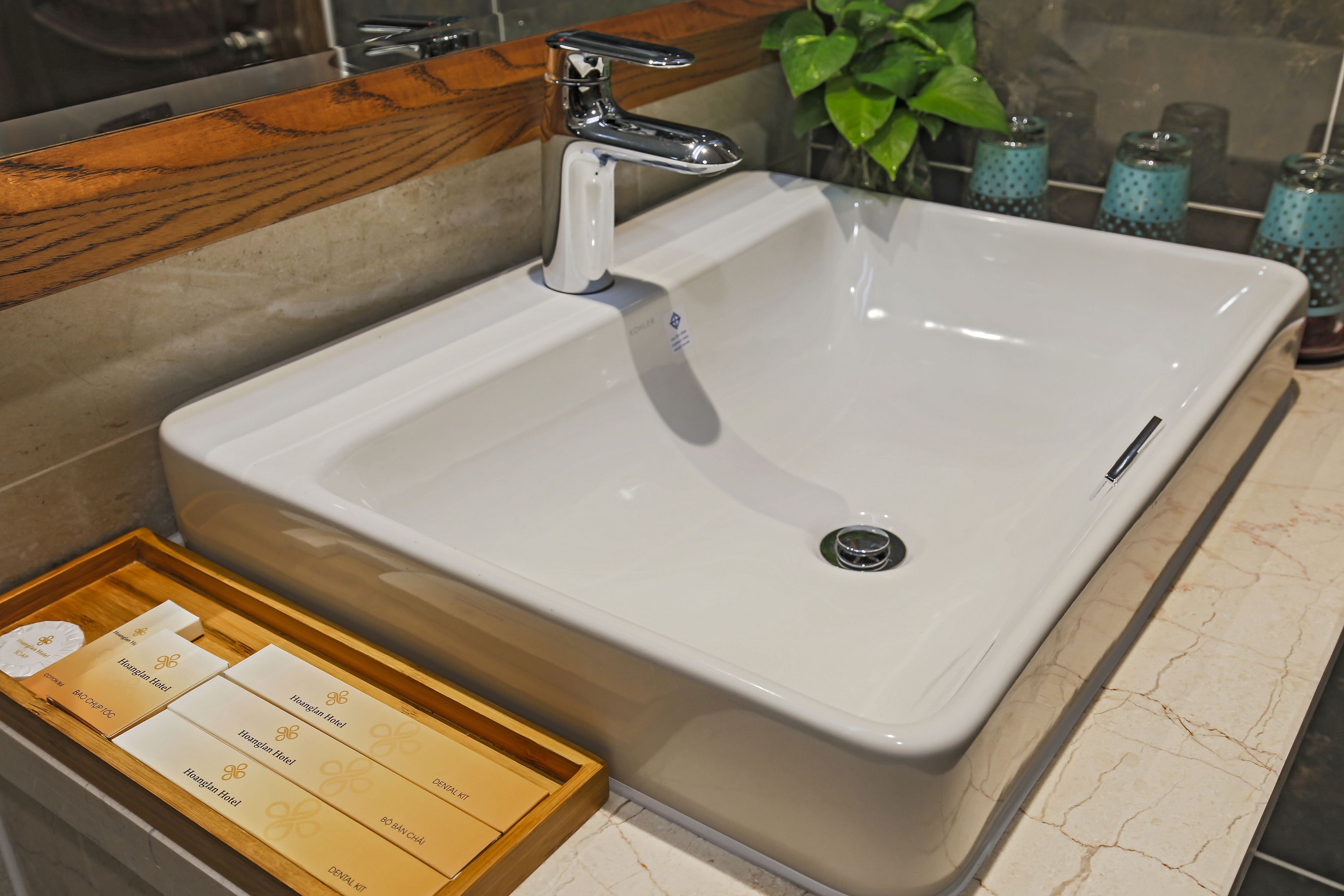 Un lavabo de salle de bain avec un plan de toilette en bois et un plateau contenant des articles de toilette.