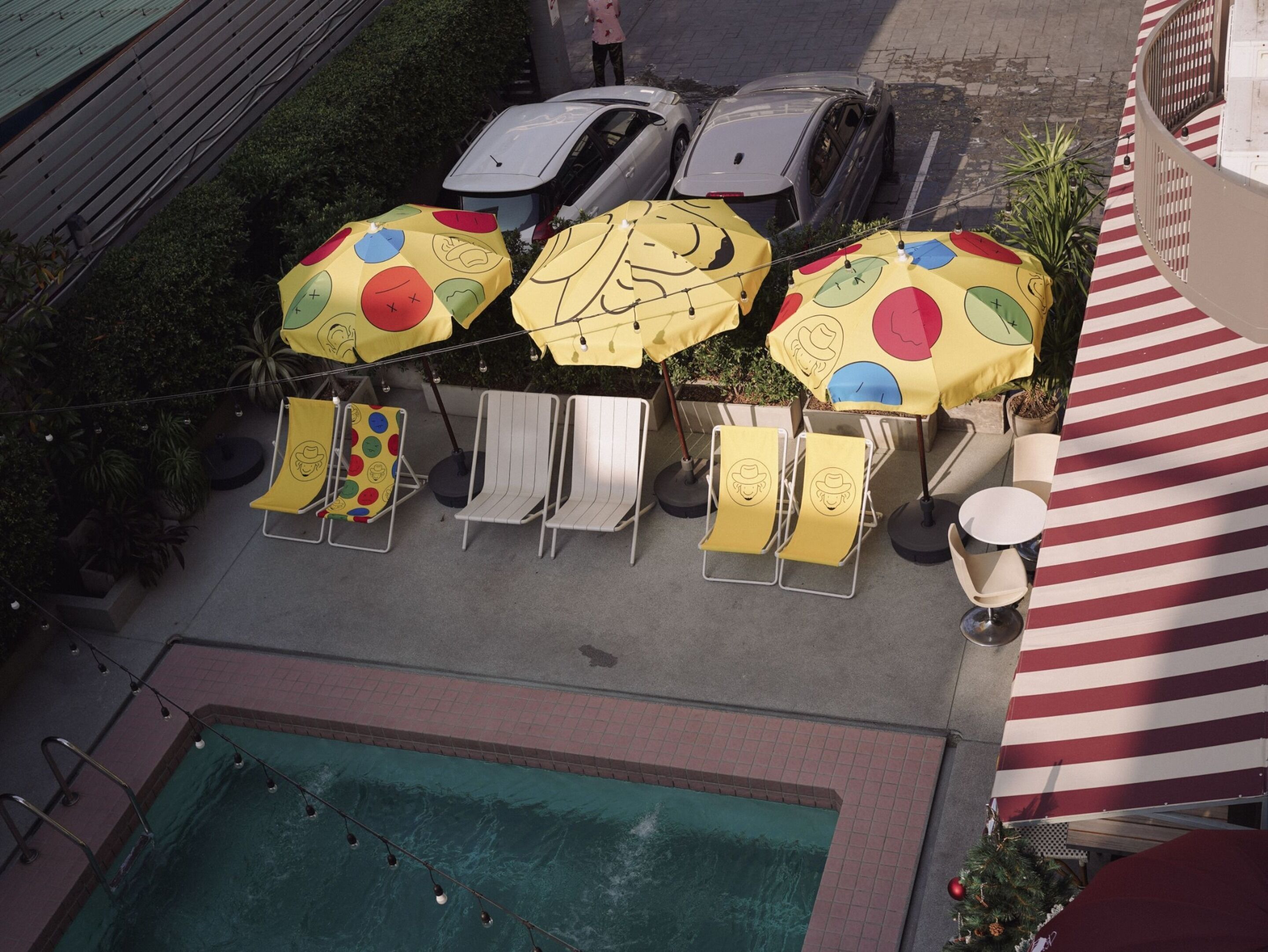 Un espacio de estar al aire libre con sombrillas, sillas y una piscina.