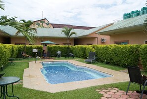 Una piscina al aire libre, sombrillas, tumbonas