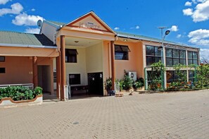 Un edificio con un acceso cubierto, una antena parabólica y un cartel que dice "Planète enfant".