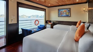 Quarto com duas camas, vista para a água, um salva-vidas e um quadro na parede.