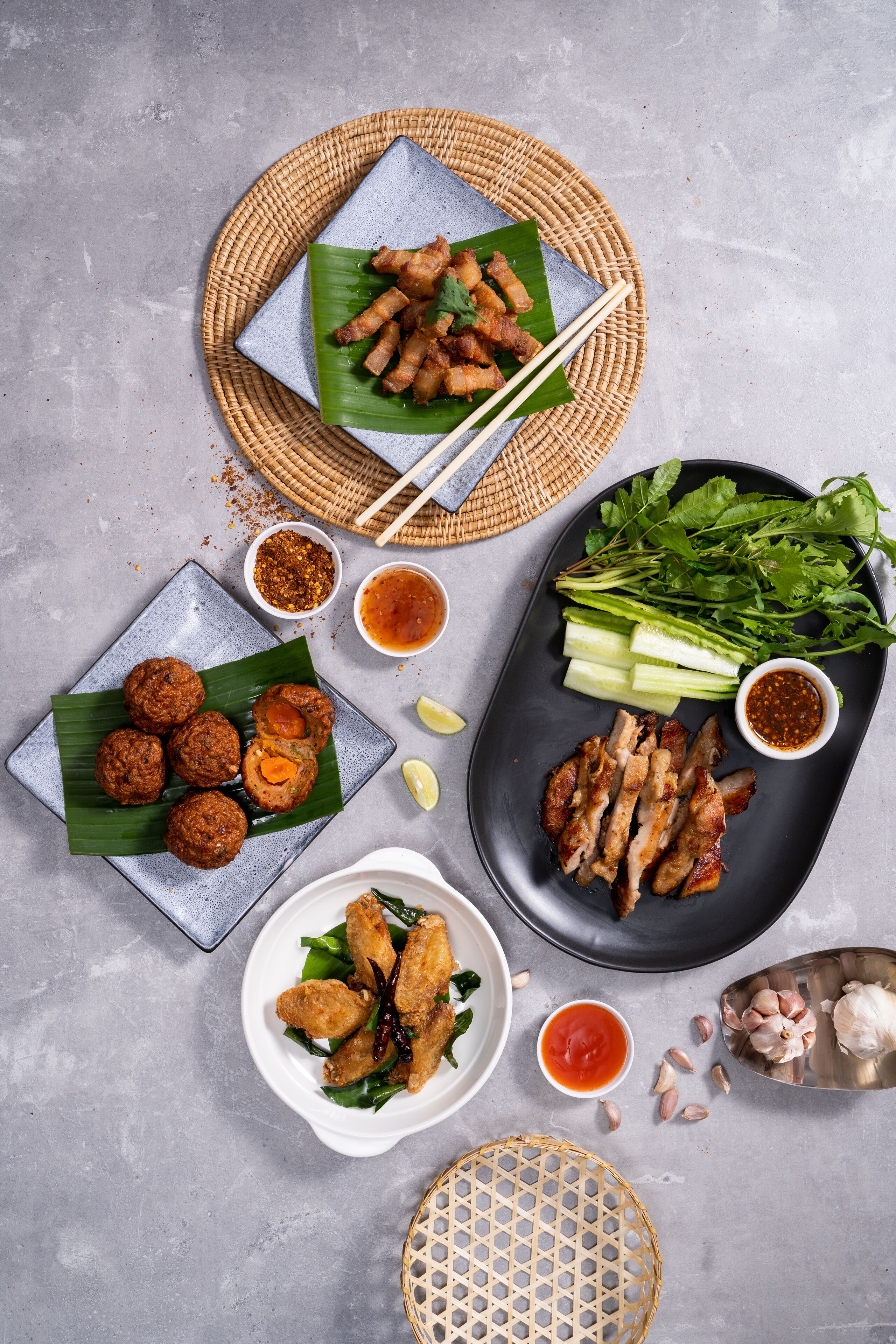 Variedad de platillos, incluyendo frituras, verduras frescas y salsas sobre una mesa.