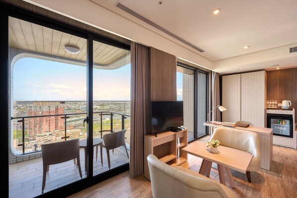A modern living room with a balcony, a flat-screen TV, a dining area, and a kitchen. - Cuncyue Hot Spring Resort (Luodong)