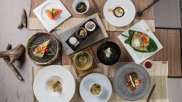 Variedad de platos y tazones dispuestos sobre una mesa con palillos y un posavasos.