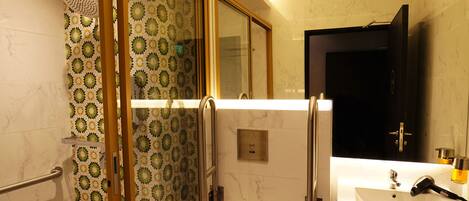Une salle de bain moderne avec une douche à parois de verre, des toilettes, un lavabo et un miroir.