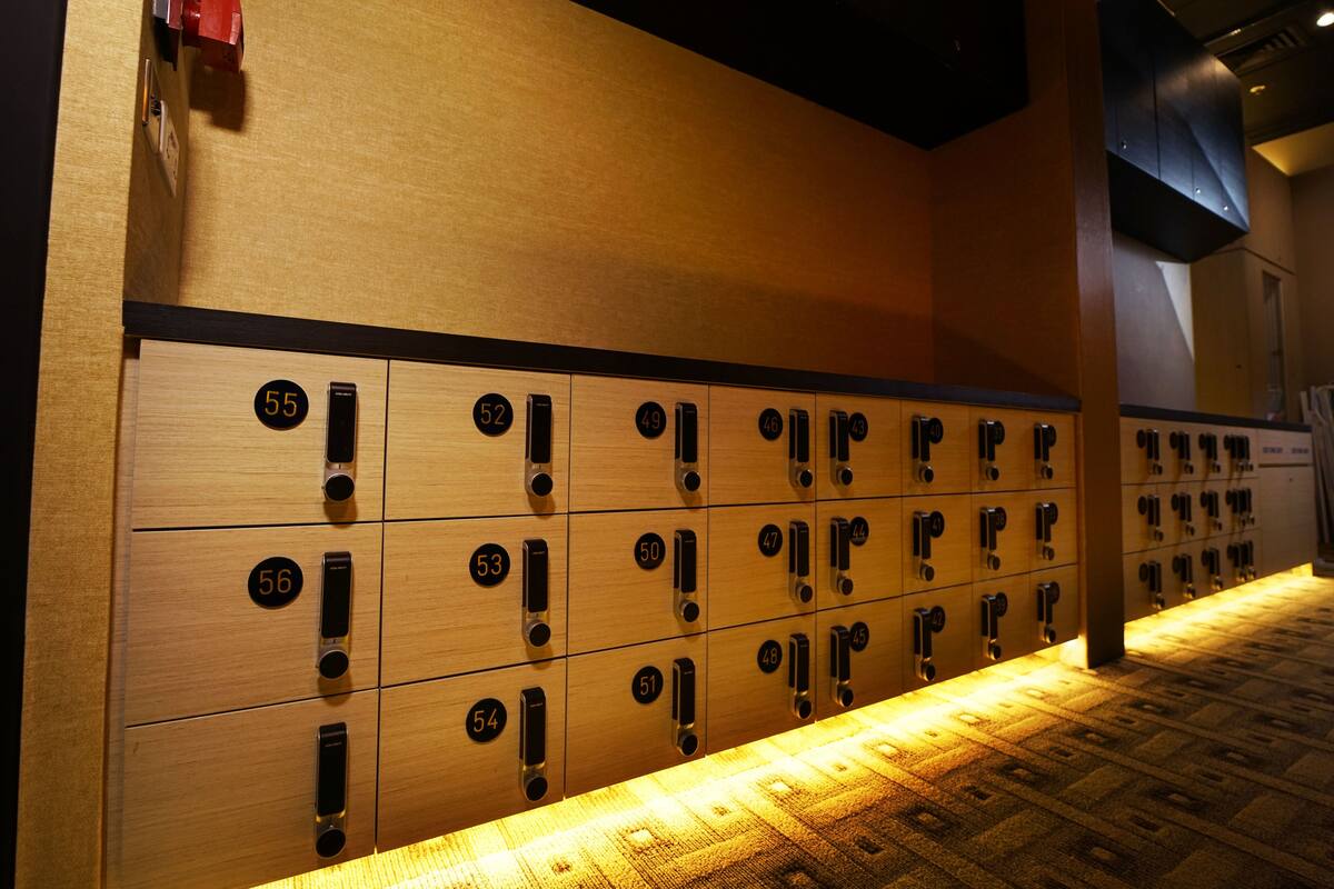 A row of wooden lockers with numbers on them, likely for guests to store their belongings.