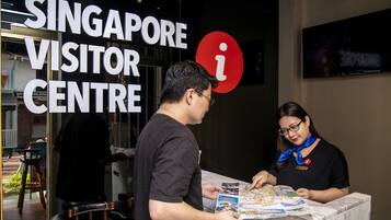 A man and a woman at the Singapore Visitor Centre, discussing a map.