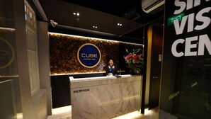 A reception desk with a 'CUBE Kampong Glam' sign, a reception area, and a 'VIS CEN' sign. - CUBE Boutique Capsule Hotel @ Kampong Glam (Singapore)