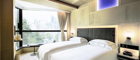 A hotel room with two beds, a large window with curtains, a city view, and a modern design.