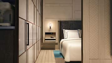 Habitación de hotel pequeña con cama, mesita de noche y lámpara fijada a la pared.