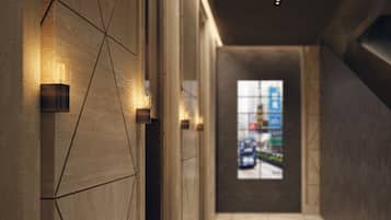 A hallway with geometric wall patterns and recessed lighting.