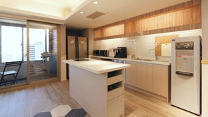 A modern kitchen with a central island, wooden cabinets, and a refrigerator. - Sky19 Hotel (Taipei)