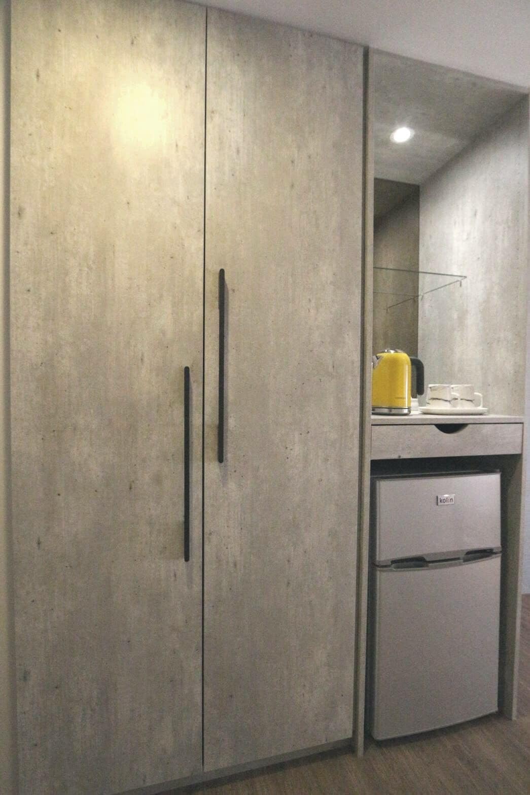 Een kitchenette met een koelkast, een wastafel en een aanrecht.