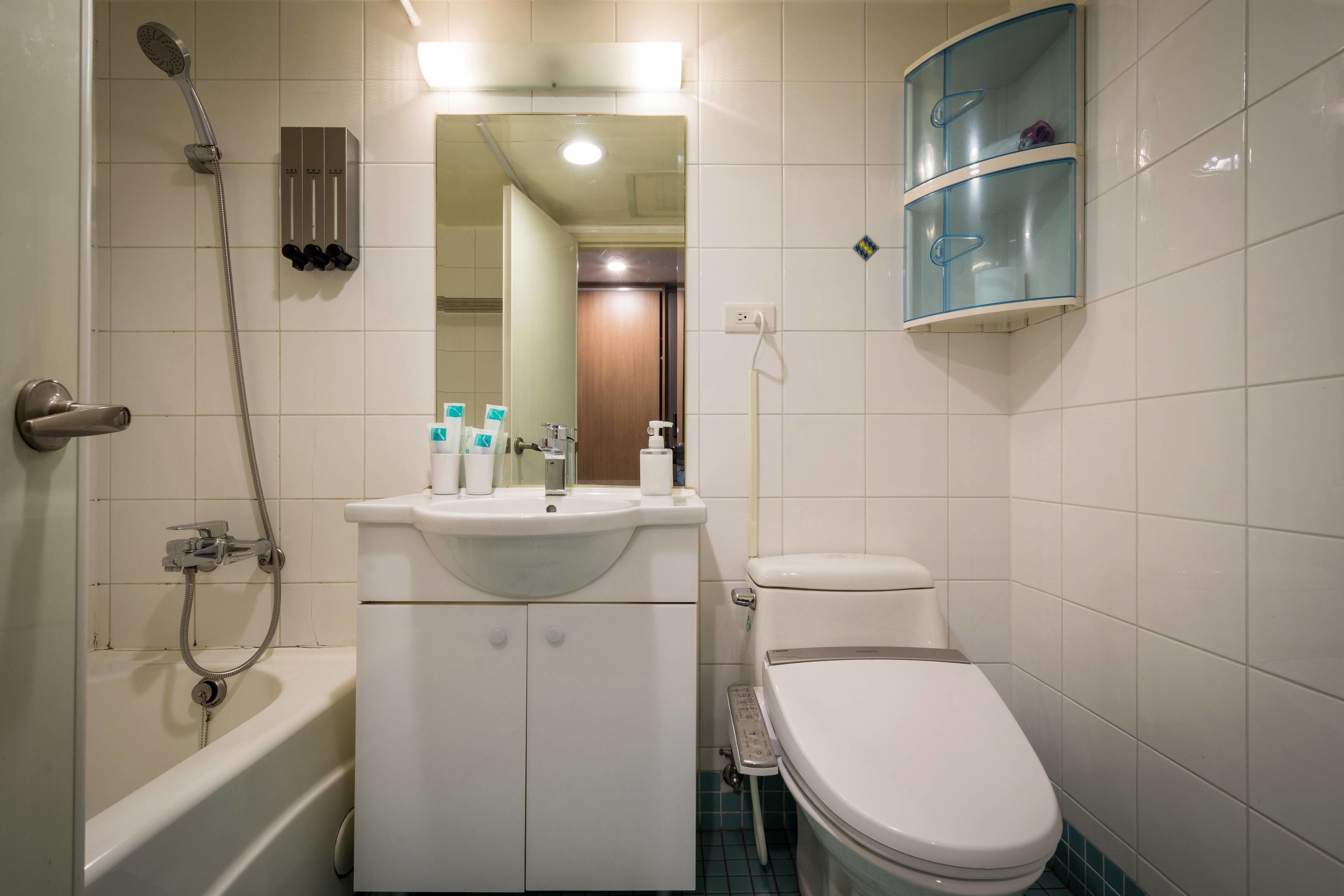 A bathroom with a bathtub, toilet, sink, and a glass shower enclosure.