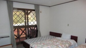 Un dormitorio con dos camas, una ventana con cortinas y vistas al exterior.