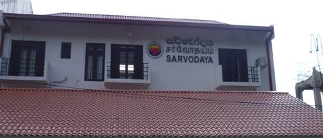 A building with a tiled roof and a sign that reads "abebita fitbuthindi SARVODAYA".