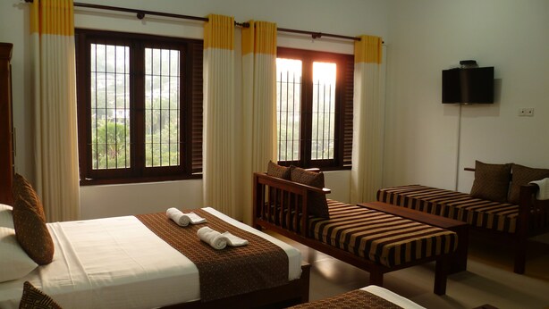 A hotel room with two beds, a TV, and large windows with curtains. - Sarvodaya Samma Vaasa Resedence (Kandy)