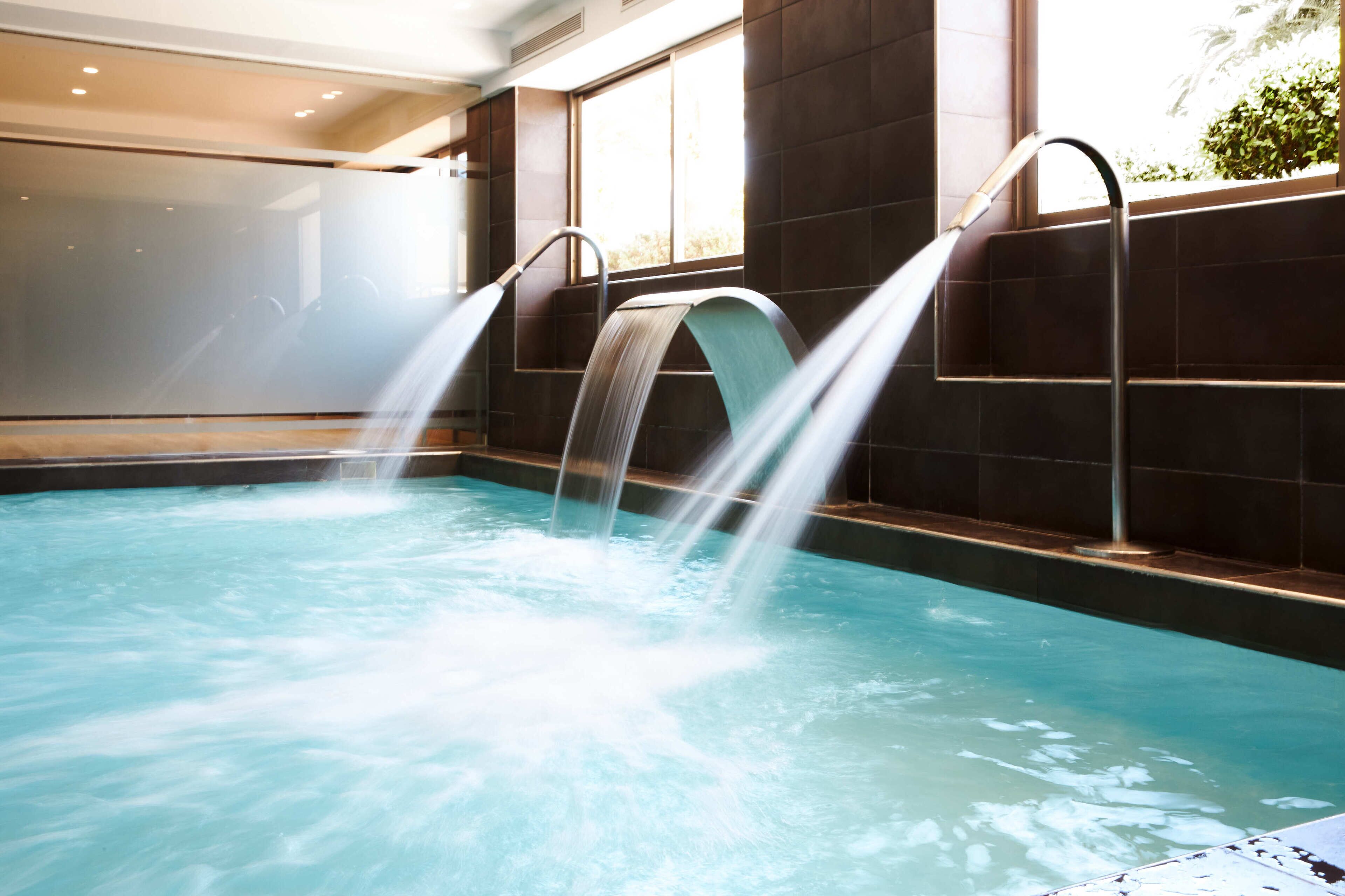 Una piscina con varios chorros de agua.