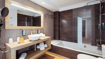 A modern bathroom with a large mirror, a sink, a bathtub, and a shower.