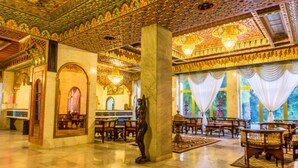 A spacious lobby with ornate ceiling and chandeliers, marble columns, and a statue. - Hotel Jugurtha Palace (Gafsa)