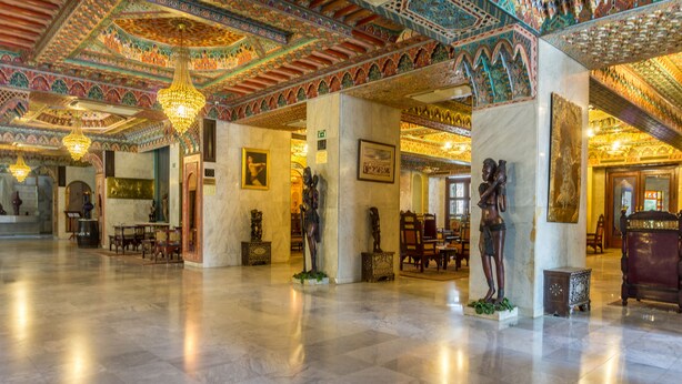 A spacious lobby with marble floors, ornate ceiling decorations, and classical statues. - Hotel Jugurtha Palace (Gafsa)