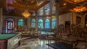A grand hall with a pool table, ornate chandeliers, and rows of chairs. - Hotel Jugurtha Palace (Gafsa)