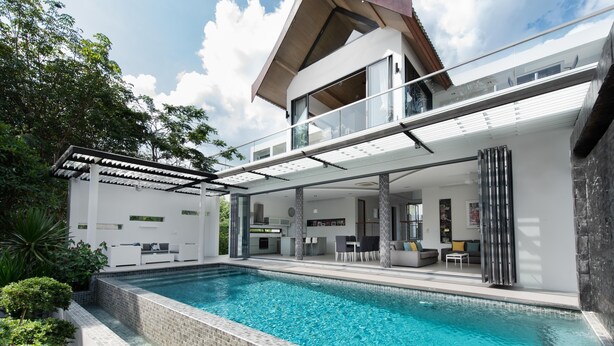 Una casa moderna con piscina, un espacio exterior cubierto y una estructura de dos pisos.