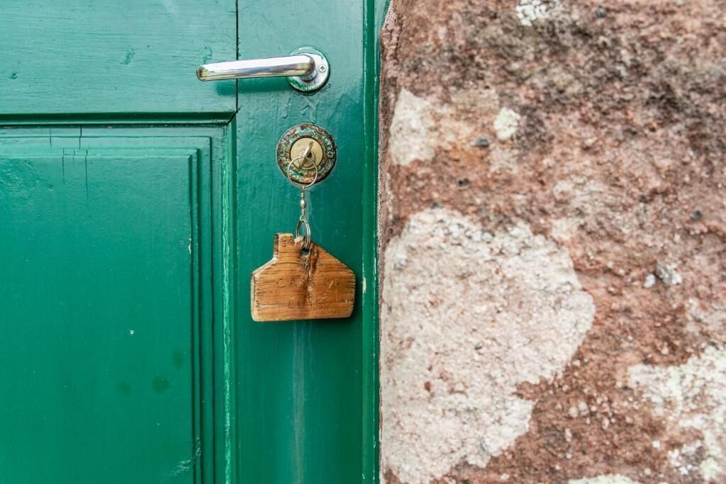A green door with a metal handle and a keyhole.