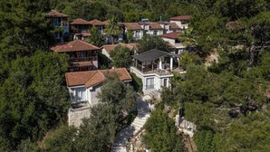 A cluster of houses with a central building featuring a balcony and a covered patio.