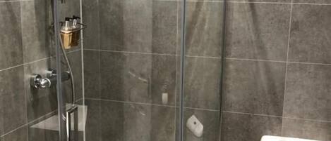 A shower enclosure with a glass door, a toilet, and a sink.