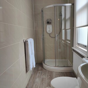 Un bagno moderno con doccia vetrata, un water e una vasca.