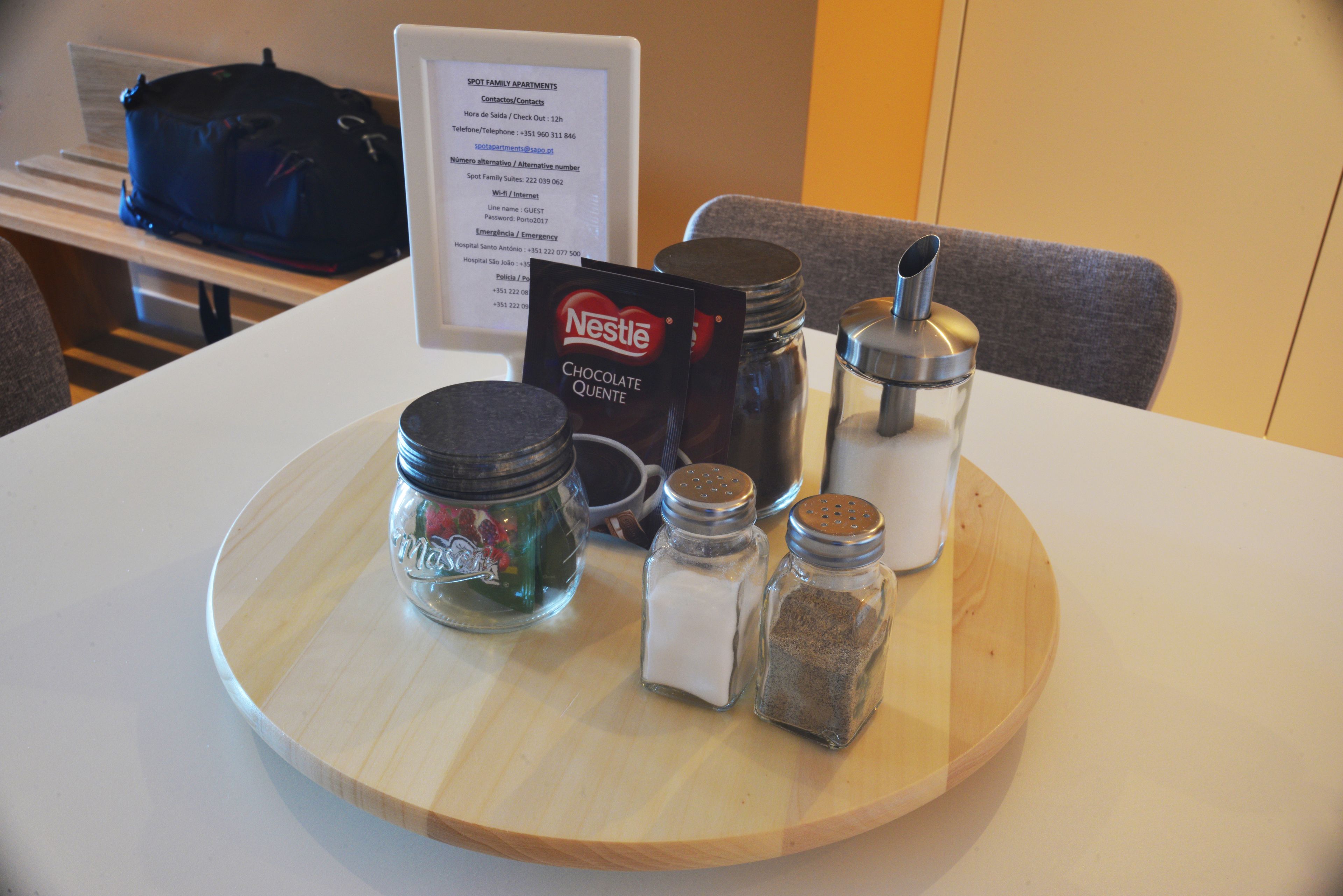 A tray with salt, pepper, and a Nestle chocolate packet on a hotel table.