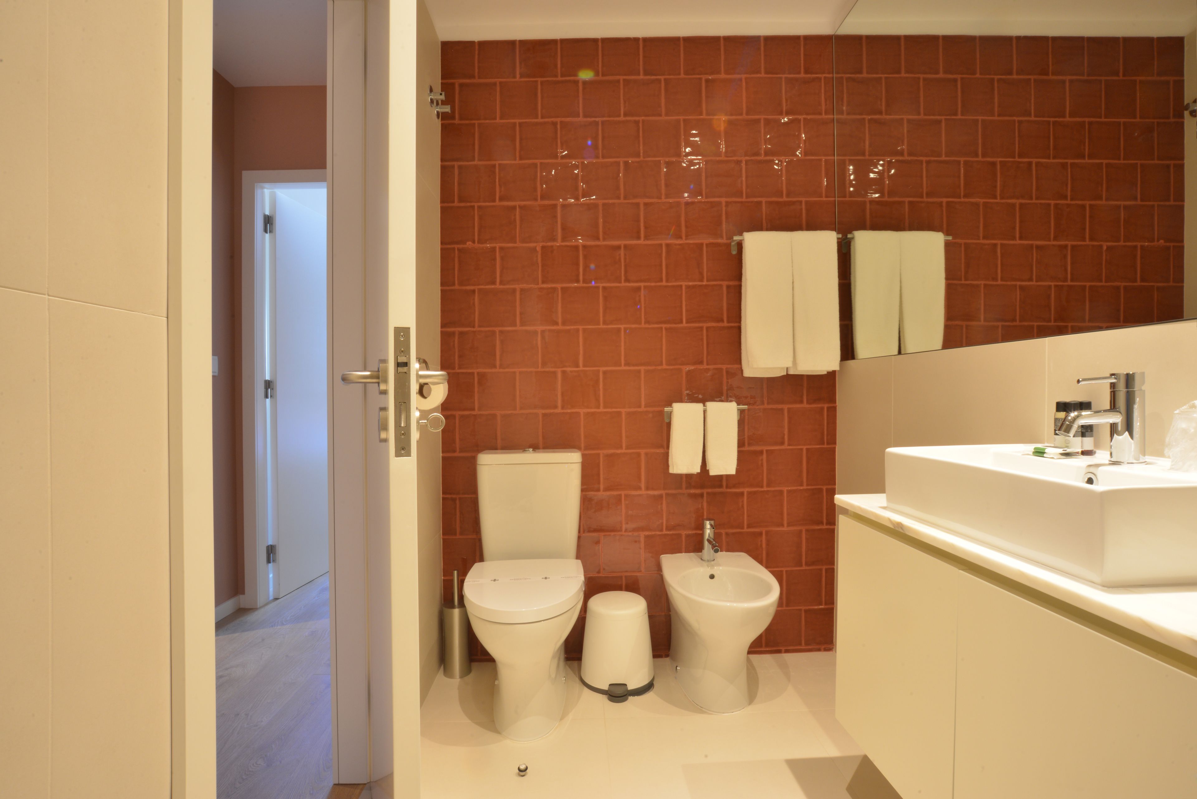 A modern bathroom with a toilet, bidet, and sink.