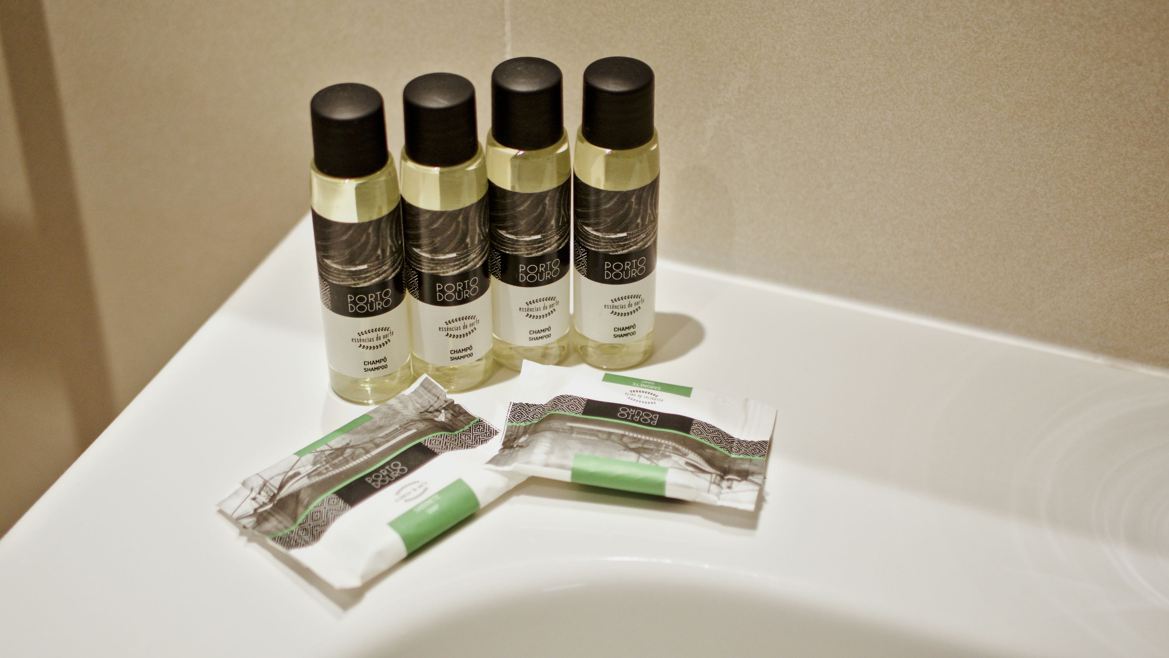 Four bottles of Porto Douru shampoo and two packets of hair care products on a white surface.