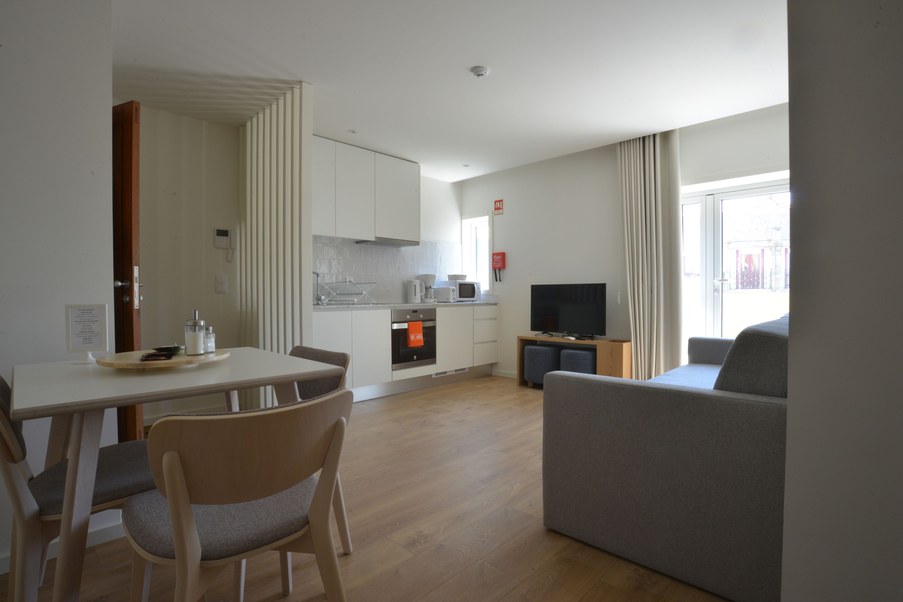 Een moderne woonkamer met een bank en een eethoek met een tafel en stoelen.