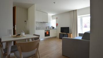 A modern living room with a sofa and a dining area with a table and chairs.